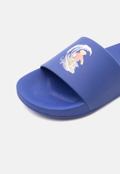Μπλε σανδάλι με λουρί και υφή στην επιφάνεια του πέλματος, με γραφικό εικόνας ενός αρκούδου που κάνει σερφ σε κύμα.