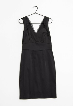 Robe noire à la coupe cintrée, avec des accents en dentelle au niveau des épaules et un décolleté en V. Fabriquée en tissu lisse, avec un ourlet sécurisé en bas.