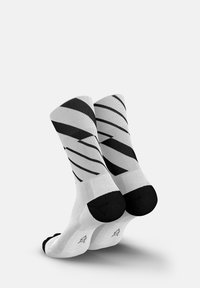 Schwarz-weiße Socken mit diagonalen Streifenmuster aus gewebtem Stoff. Verfügt über verstärkte schwarze Fersen- und Zehenbereiche.