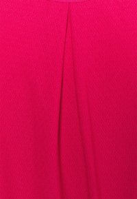 Látka fuchsiové šaty s texturovaným povrchem a centrálním skladem. Hladký povrch bez viditelných vzorů nebo kovových prvků.
