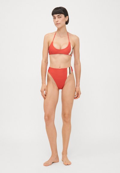 Sarkans bikini komplekts ar trīsstūra augšdaļu un plānām siksniņām, kā arī augsto jostu apakšdaļu. Sānu akcenti krēmkrāsā un brūnā, gluda auduma tekstūra.