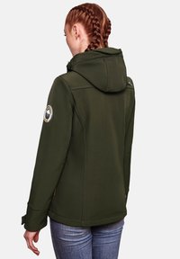 Dark green softshell jacket with a hood, featuring a circular patch on the left sleeve and zippered pocket detail on the upper back.