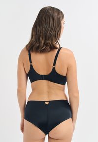 Set di reggiseno nero e mutandine a vita alta. Tessuto liscio e elasticizzato con un leggero lucido. Spalline regolabili e dettaglio a chiave sul retro.