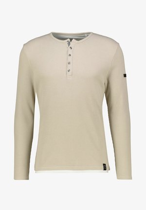 Beżowa koszula henley z długim rękawem, o teksturowanym dzianinie, z pięcioprzyciskowym zapięciem i boczną metką. Posiada okrągły dekolt i prążkowane mankiety.