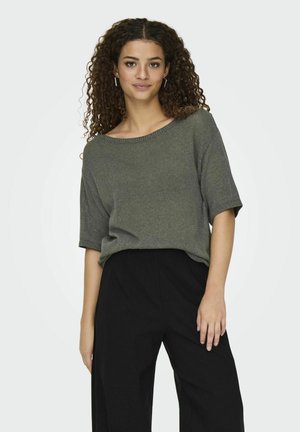 Pull à manches courtes, vert foncé, avec un col large, en tissu texturé et coupe décontractée, associé à un pantalon noir taille haute.