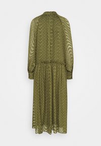 Dlouhé olivově zelené šaty vyrobené z průsvitné látky, které mají vlnitý vzor a malé bílé tečky, s dlouhými rukávy a elastickým pasem.