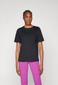 Schwarzes T-Shirt mit kurzen Ärmeln im lässigen Schnitt, aus weichem Baumwollmaterial, mit Rundhalsausschnitt und minimalistischem Design.