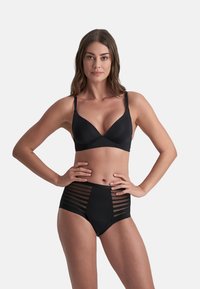 Set di lingerie nera composto da un reggiseno aderente in tessuto morbido con spalline regolabili, abbinato a slip a vita alta con ritagli a righe.
