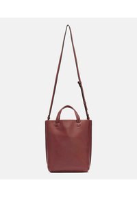 Sac fourre-tout en cuir bordeaux avec une texture lisse, deux poignées supérieures et une bandoulière réglable. Design minimaliste.