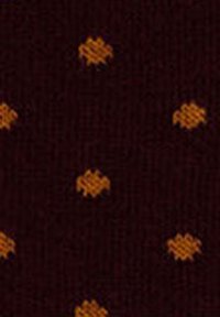 Dark fabric with a pattern of small, evenly spaced orange hexagons arranged randomly.