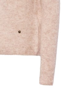 Lichtroze sweater gemaakt van zachte, gestructureerde stof met een iets losse pasvorm. Heeft een kleine gouden accentknop aan de voorkant.