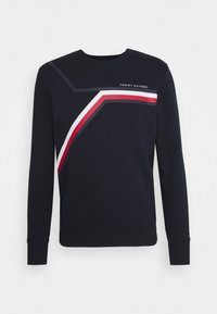 Navy sweatshirt with long sleeves and a round neck. Features geometric red and white stripes across the front and "Tommy Hilfiger" logo.