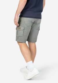 Gray cargo shorts made of cotton with two side pockets and a back pocket. Worn with white sneakers and white socks.