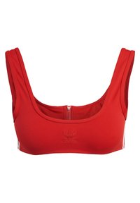 Reggiseno sportivo rosso con scollo rotondo, tessuto strutturato, chiusura con zip frontale e logo ricamato. Le strisce laterali aggiungono un dettaglio di design.
