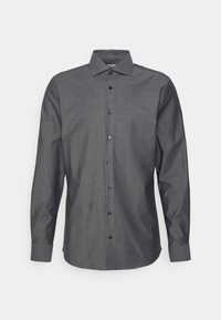 Chemise grise à manches longues avec un motif subtil, col à boutons et boutons à l'avant. Tissu lisse avec une coupe structurée et manches retroussées.