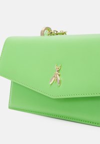 Borsa a tracolla in pelle verde con chiusura a patta, caratterizzata da un'applicazione a forma di ape in tonalità oro e una tracolla a catena. Texture liscia con bordi cuciti.