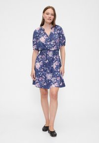 Marineblaues Blumenkleid mit rosa und weißen Rosen; kurzärmelig, mit Kragen, elastischer Taille und ausgestelltem Rock; leichter Stoff mit weicher Textur.