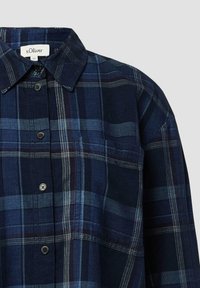 Navyblauwe geruite shirt met een knoopsluiting, voorzien van donkerblauwe en lichtblauwe strepen, en een borstzak. Gemaakt van een zachte, gestructureerde stof.