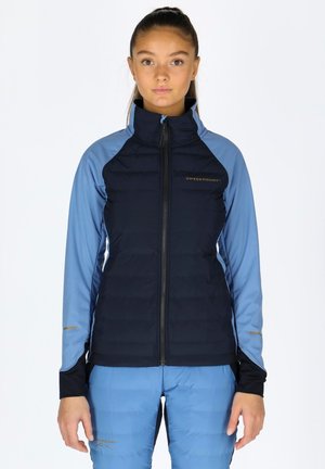 Navy and light blue jacket with a zip closure, quilted body, and smooth sleeves. Features logo on the chest and gold accents on sleeves.