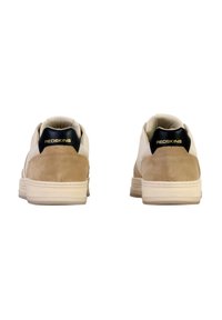 Sneaker beige e crema con suede e pelle liscia, dotate di un tallone nero. Marchio dorato sul retro. Suola in gomma piana.