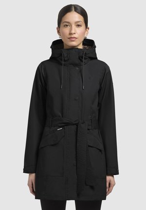 Manteau noir imperméable avec capuche, devant boutonné, cordons de serrage, taille ceinturée et deux poches avant. La doublure intérieure présente un motif.