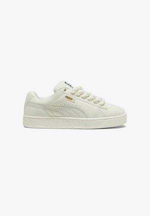 Witte suède sneakers met een getextureerde rubberen zool, ronde neus en vetersluiting. Heeft gouden branding aan de zijkant en een zwarte accenten op de tong.