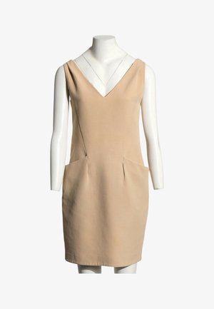 Robe beige sans manches avec encolure en V et poches latérales présentée sur un mannequin blanc sur un fond uni.