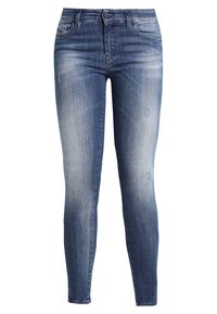 Skinny fit denim jeans in a medium blue wash with light distressing, five-pocket style, slight fading, and a button closure at the waist.