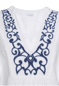 Top bianco con scollatura a V profonda e ricami floreali blu navy dettagliati lungo il collo. Tessuto in lino, design leggero.