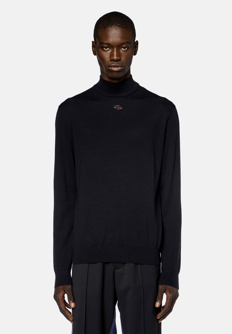 Maglione a collo alto di fine maglia colore nero con maniche lunghe; presenta un piccolo logo marrone sul petto; texture liscia.