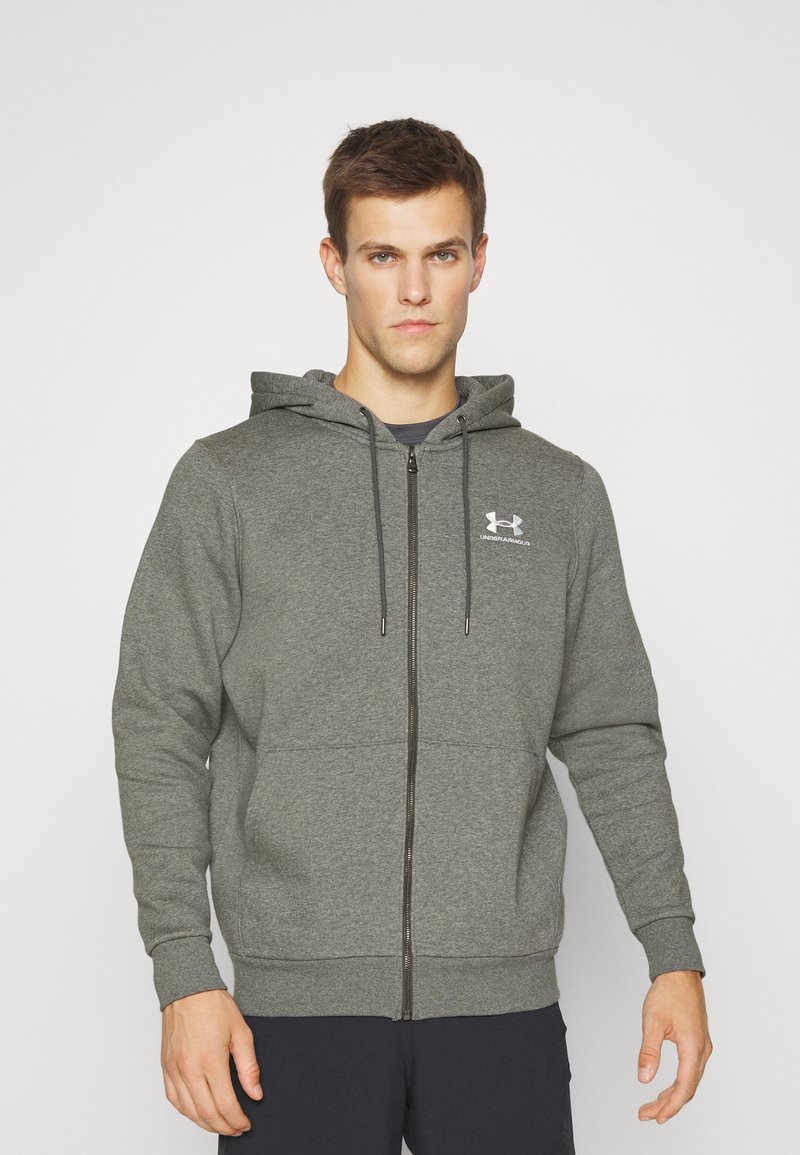 Grå zip-up hoodie med hætte, lavet af blødt stof. Har en frontlynlås, elastiske ærmer og et lille logo på brystet.