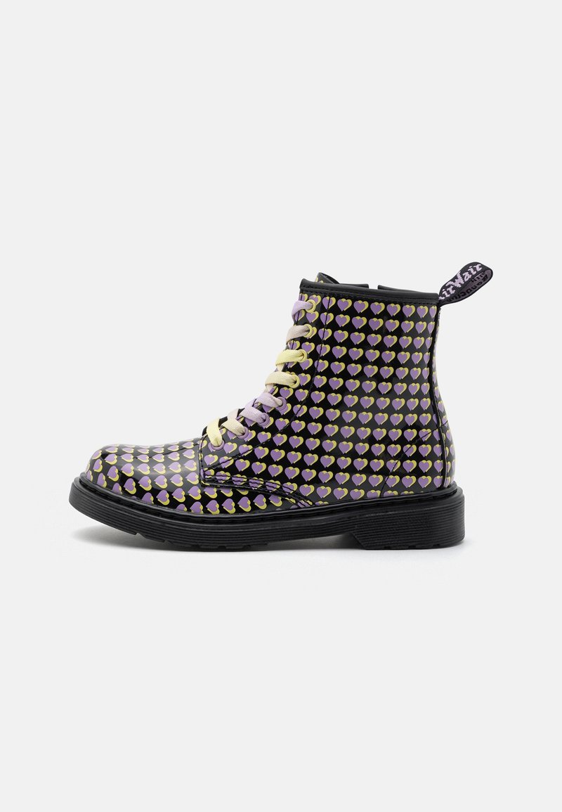 Bottine noire à lacets avec motif de cœur jaune et violet et une semelle noire épaisse, montrée de profil sur fond blanc.