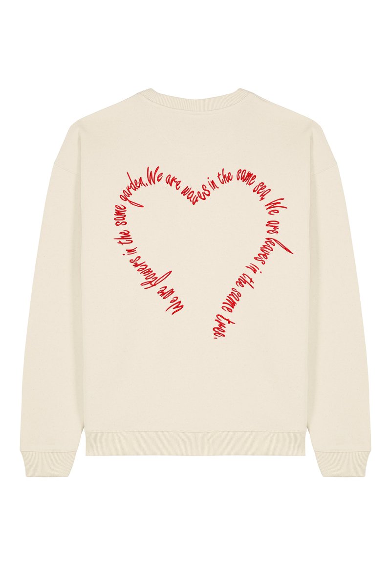Felpa crema con grafica a forma di cuore rosso sul retro che presenta un testo scritto a mano. Materiale morbido, polsini e orlo a costine.