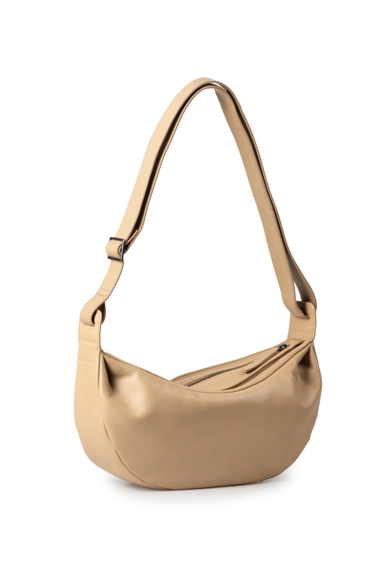 Beige leather shoulder bag with a curved shape, adjustable strap, and top zipper closure. Smooth texture with minimal hardware details.