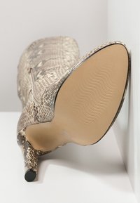 High-heeled shoe featuring a textured snakeskin pattern in shades of beige and brown, with a sleek silhouette and a smooth, contoured sole.