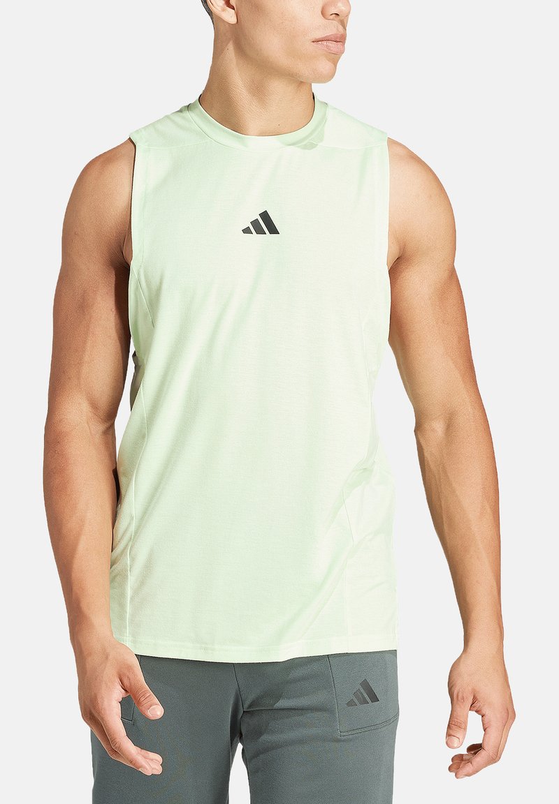 Top atletico senza maniche di colore verde chiaro con scollatura rotonda, caratterizzato da un piccolo logo Adidas nero sul petto e un design aerodinamico.