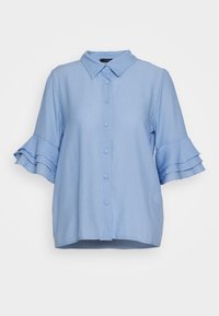 Ljusblå skjorta med krage. Korta ärmar med lager av volanger. Tillverkad av texturerat tyg, med en lös passform och rak fåll.