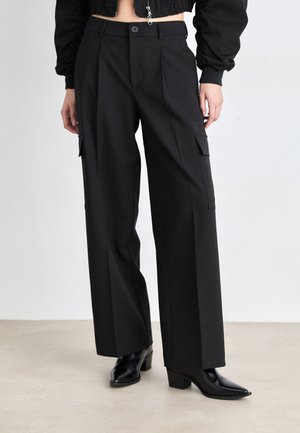 Black wide-leg cargo pants with a high waist, featuring two side pockets, a smooth texture, and a classic design paired with heeled boots.