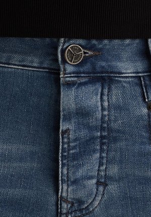 Blå denim jeans med en kontrastfarvet sort ribbet talje og sølvfarvet trykknap. Har et klassisk fem-lomme design med let slidte effekter.