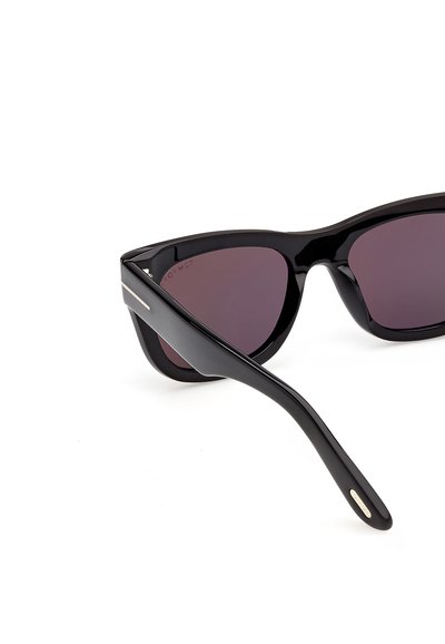 Černé brýle ve tvaru kočičího oka s tmavými tónovanými čočkami a lesklými rámečky na bílém pozadí.