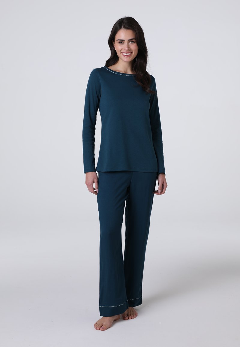 Maglietta verde acqua a maniche lunghe con scollatura rotonda e cuciture decorative abbinata a pantaloni larghi coordinati. Tessuto morbido. Modello a piedi nudi.