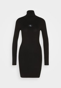 Abito nero a maglia con collo alto e maniche lunghe. Presenta una patta con logo a contrasto sul davanti. Design aderente.