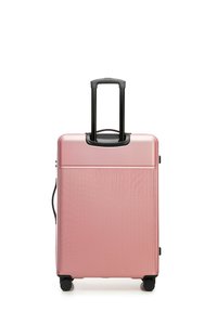 Hartschalenkoffer in Pink mit vertikalen Rippen, einem ausziehbaren schwarzen Griff und vier schwarzen Rollen für Mobilität.