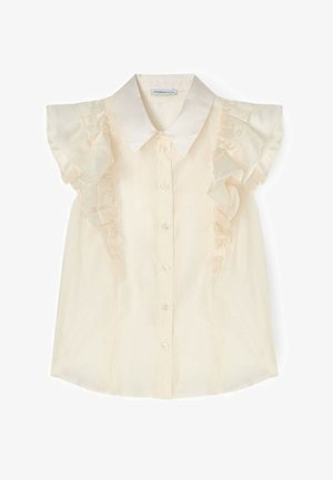 Blusa sin mangas de color crema con detalles de volantes a lo largo de los hombros y cierre de botones en la parte delantera, con un clásico cuello puntiagudo.