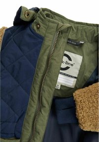 Gequilted jack met marineblauwe en olijfgroene secties, voorzien van een getextureerde tan nepbont kraag en ribgebreide mouwboorden. De rits en het label zijn zichtbaar.