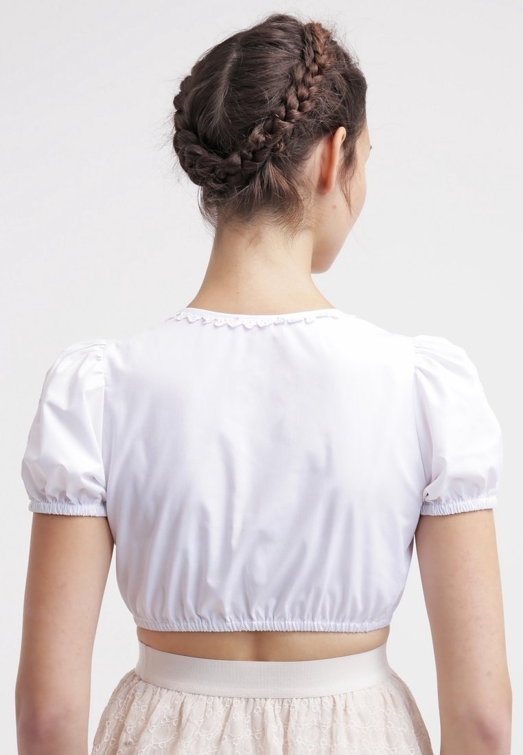 Top blanco cortado con mangas abullonadas, banda elástica en la cintura y detalle de ondas en el escote. Textura de tela suave.