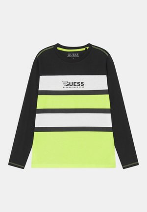 Czarna koszula z długim rękawem, z białymi i neonowożółtymi poziomymi paskami, z czarnym logo „GUESS Established 1981” na piersi.