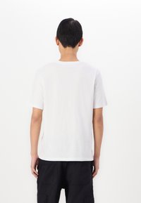 Tricou alb cu mânecă scurtă, guler rotund și croială dreaptă. Fabricat din bumbac ușor, cu o textură netedă. Fără modele sau grafica vizibile.