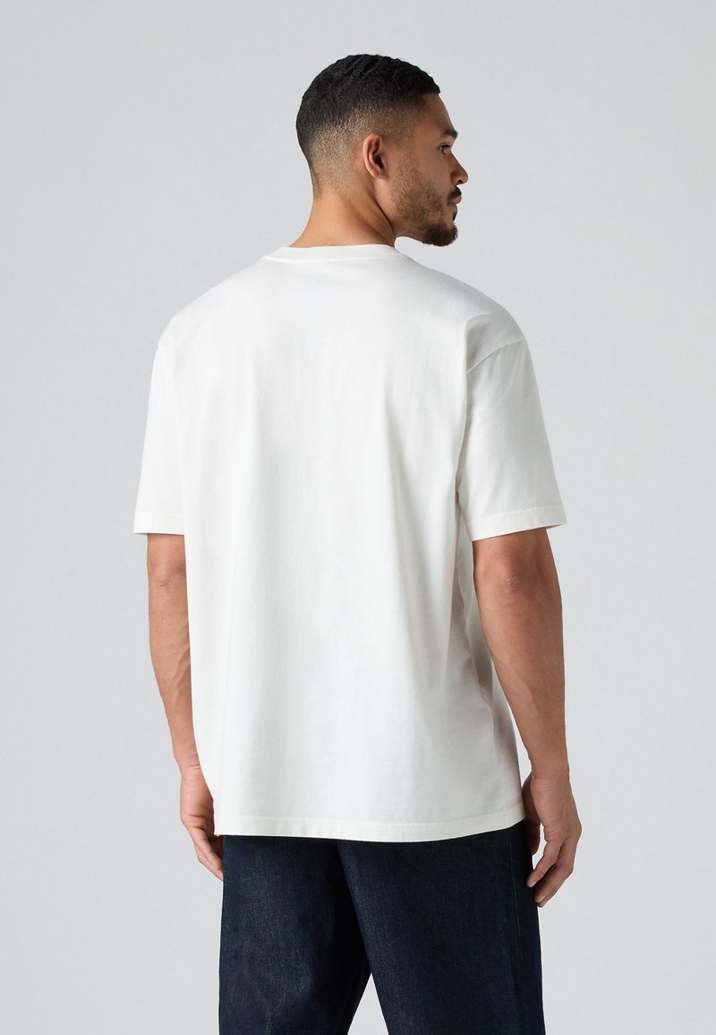 Biała koszulka z krótkim rękawem, okrągłym dekoltem, wykonana z miękkiej bawełny. Posiada luźny krój, gładki design i prosty dół.