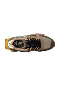 Zapatilla marrón y verde con malla texturizada y materiales de ante, que cuenta con cordones negros, acentos amarillos y una suela gruesa multicolor.